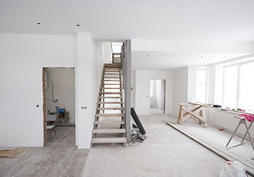 There is a wooden staircase in the middle of the room.