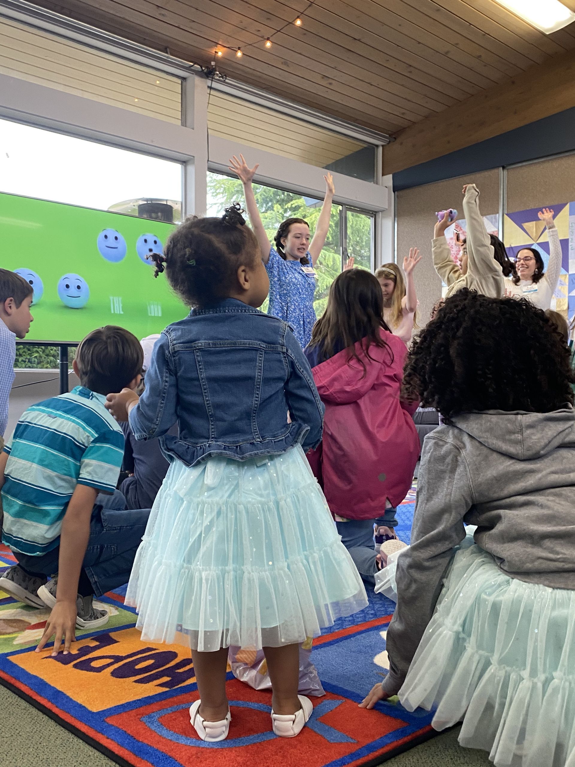 A group of children are sitting on the floor in a room.