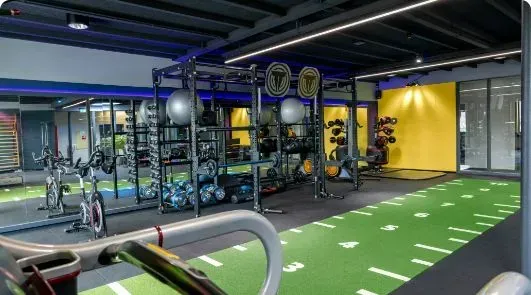 A gym filled with lots of exercise equipment and a treadmill.