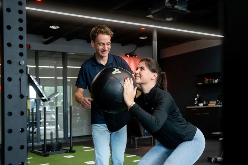 Medewerker van Revital  begeleidt een cliënt tijdens een oefening flexibiliteit