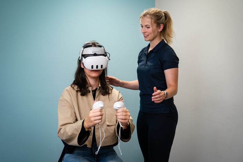 Medewerker Revital Fysio | Werk | Fit begeleid een cliënt met de VR bril