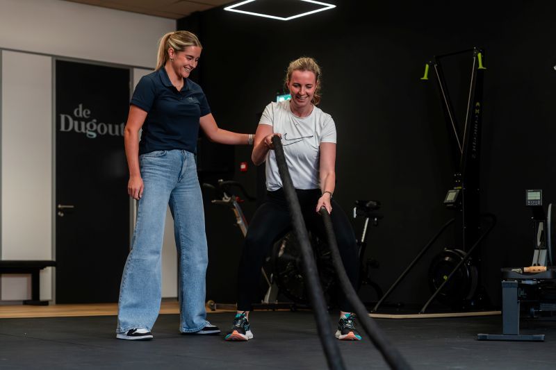 Medewerker van Revital Fysio | Werk | Fit die een cliënt begeleid tijdens een oefening om haar kracht en uithoudingsvermogen te verbeteren