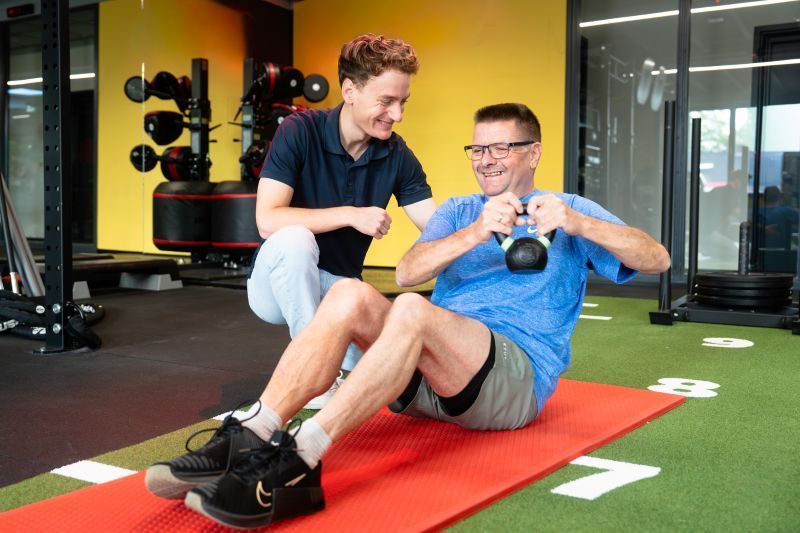 Medewerker Revital Fysio | Werk | Fit is met een deelnemer van Active Life een oefening aan het uitvoeren