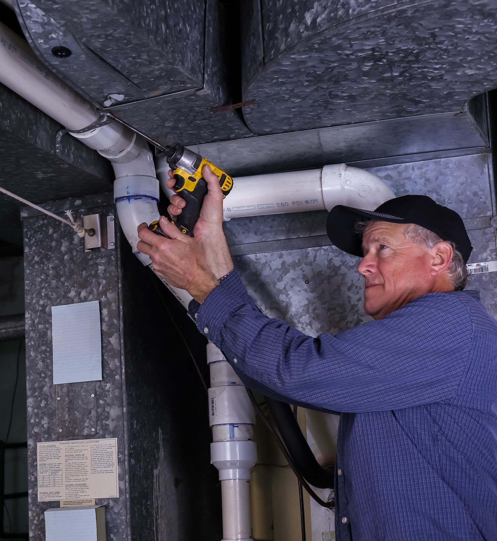 furnace worker repairing system ductwork