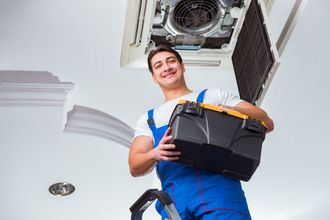 worker repairing ceiling AC