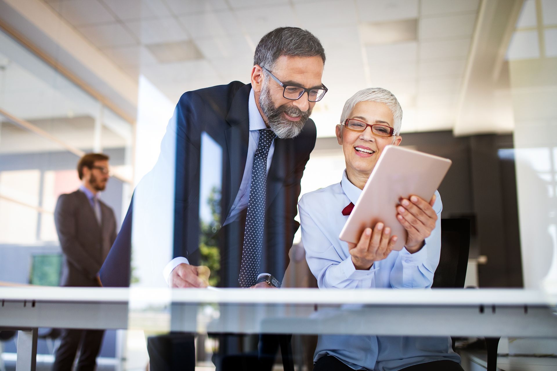 Accounting tax preparation of a business man in a tie and a professional woman holding a tablet