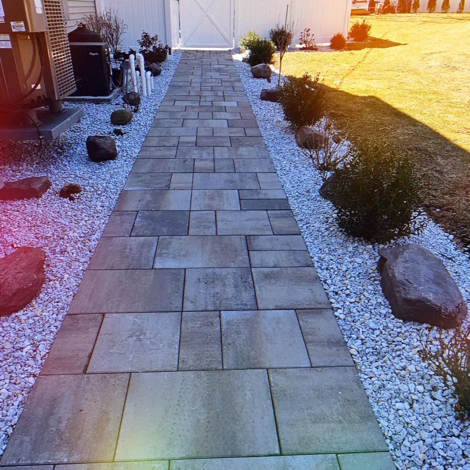 A brick walkway surrounded by gravel and rocks