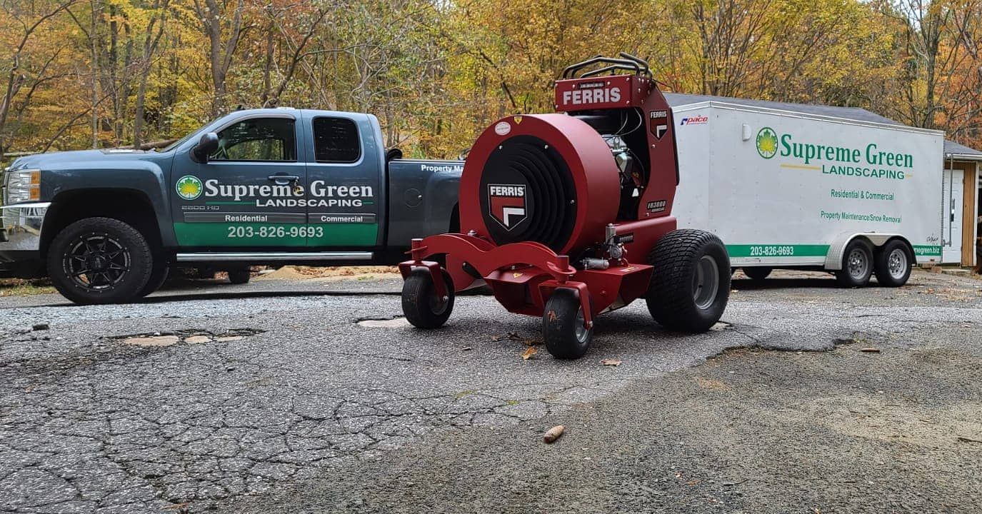 A lawn mower is being towed by a truck.
