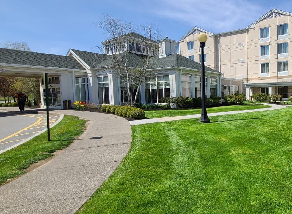 A large white building with a lush green lawn in front of it.
