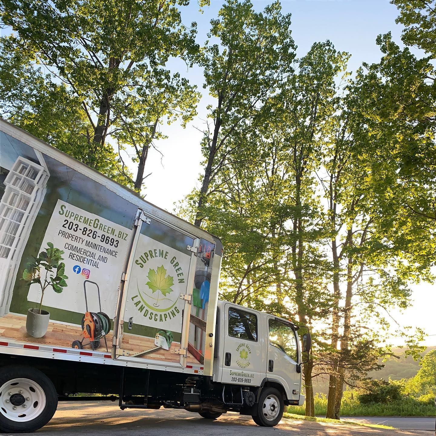 A moving truck is parked on the side of the road.
