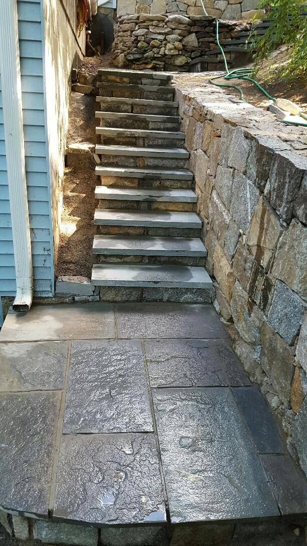 A set of stairs leading up to a stone wall.