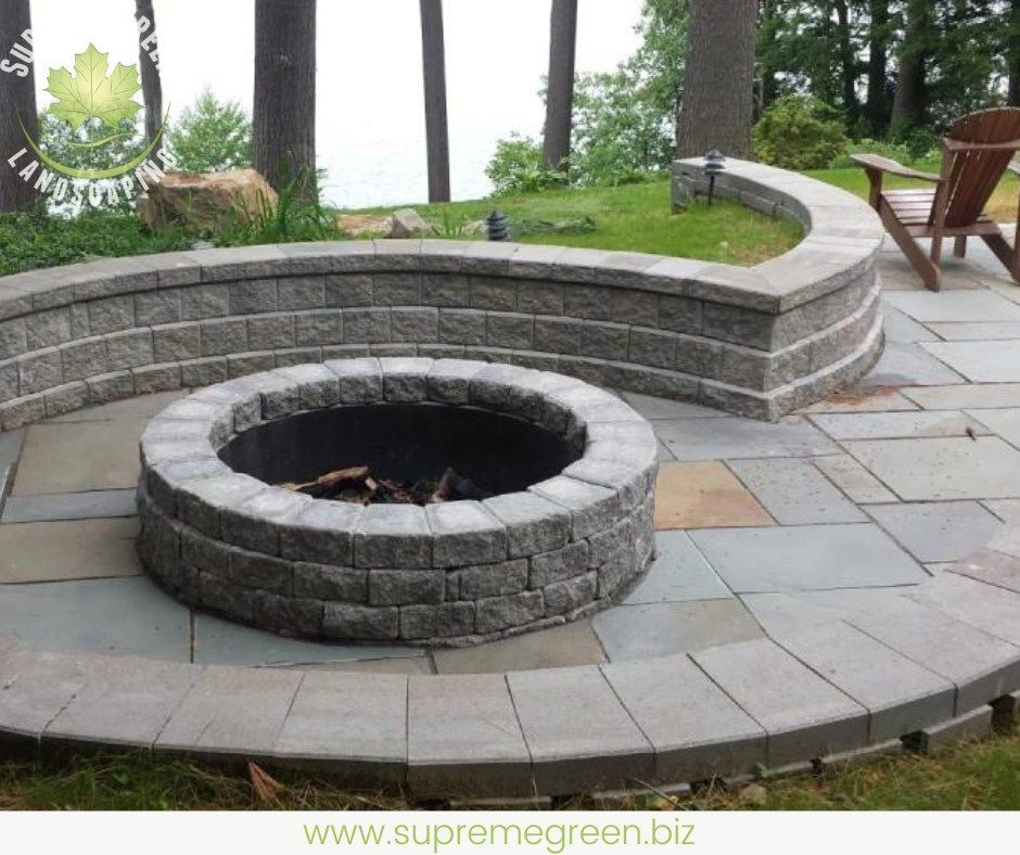 A fire pit is surrounded by a stone wall on a patio