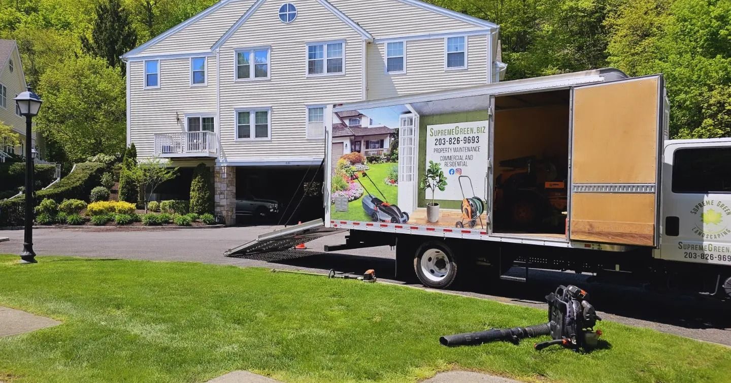 A truck is parked in front of a house with the door open.