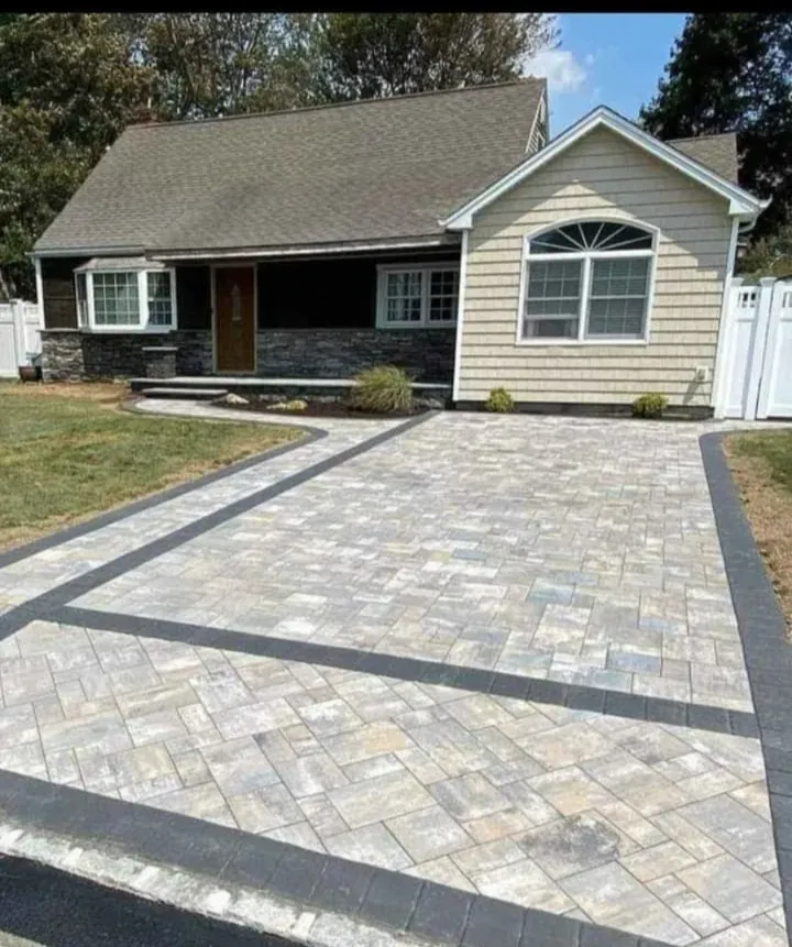 A house with a brick driveway in front of it.