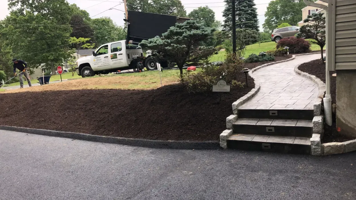 A white truck is parked in a driveway next to a house.
