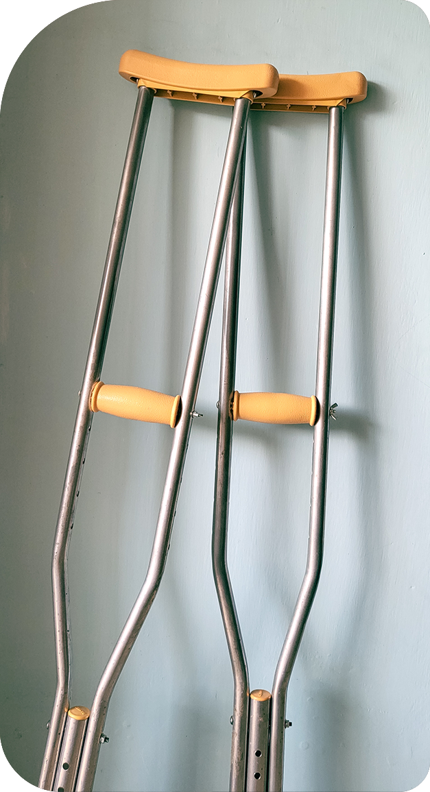 A pair of crutches are hanging on a wall.