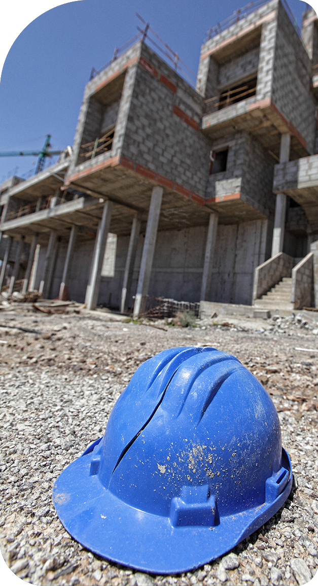 A blue hard hat is sitting in front of a building under construction.