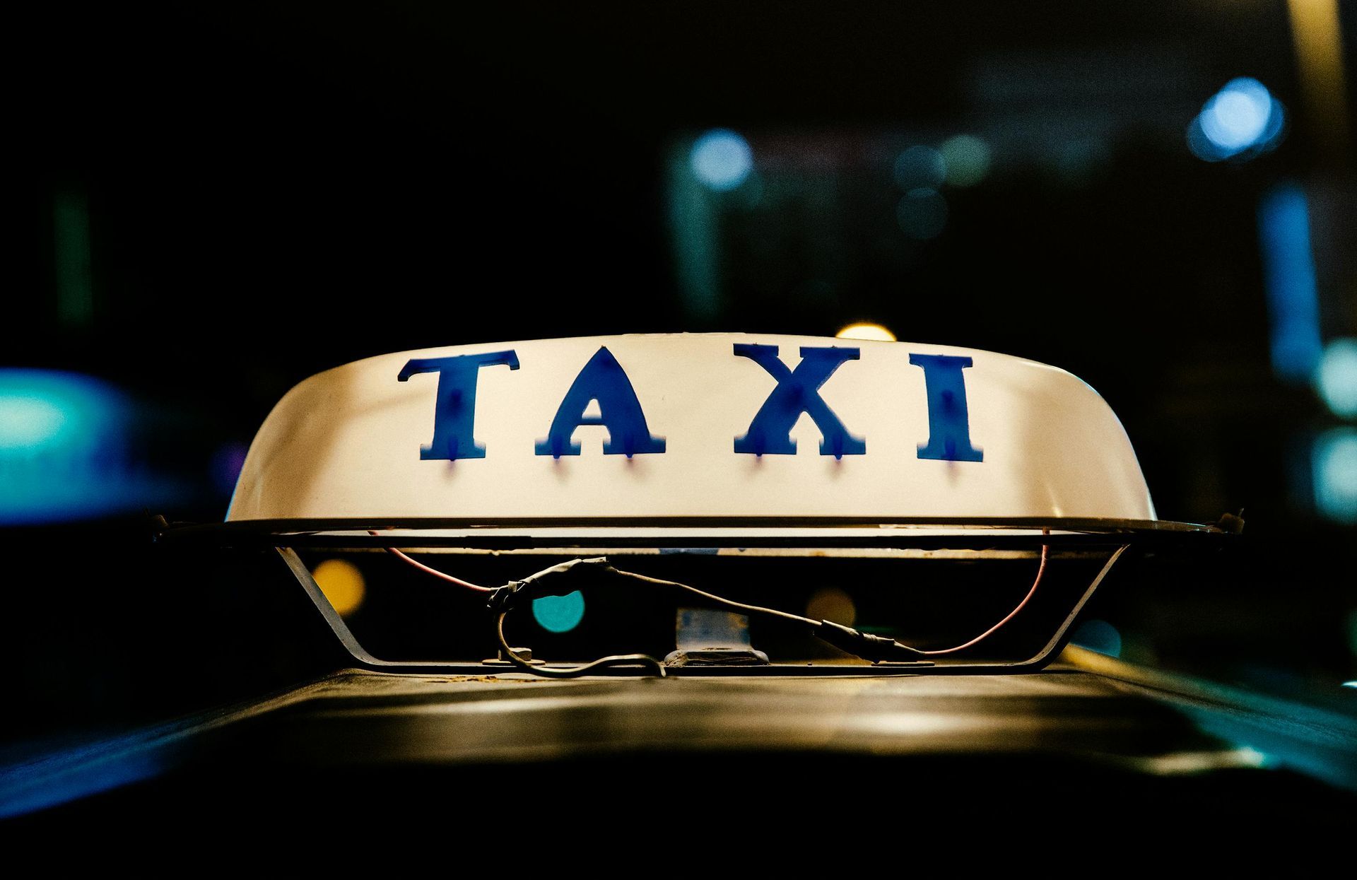 A taxi sign that is on the top of a car