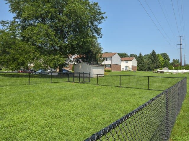 Exterior view of a grassy lawn with a chain-link fence, small shed, trees, and nearby houses. Contact us today to learn more about our pet-friendly 1, 2, 3, and 4-bedroom apartments for rent in Bethlehem, PA. At River Pointe Townhomes, you’ll enjoy a prime location near Lehigh River and all the amenities and extras that make your life comfortable. We can’t wait to welcome you home!