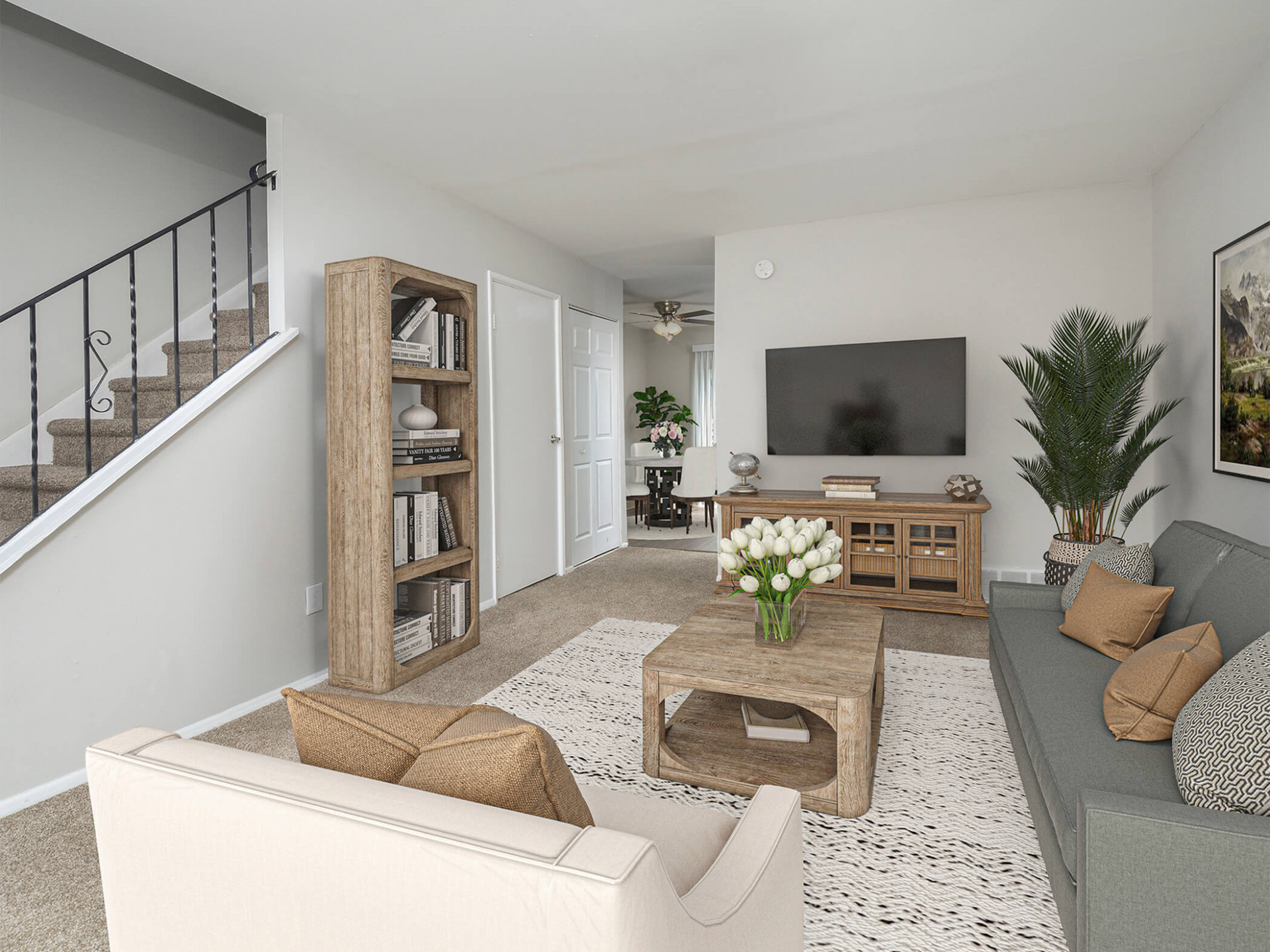 Interior living room of an apartment with a gray sofa, coffee table, bookshelf, stairs, and TV. Contact us today to learn more about our pet-friendly 1, 2, 3, and 4-bedroom apartments for rent in Bethlehem, PA. At River Pointe Townhomes, you’ll enjoy a prime location near Lehigh River and all the amenities and extras that make your life comfortable. We can’t wait to welcome you home!