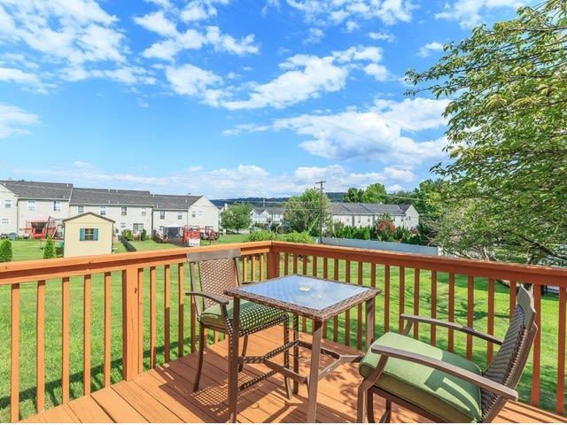 Balcony with a table and two chairs overlooking a green lawn and distant townhomes. Contact us today to learn more about our pet-friendly 1, 2, 3, and 4-bedroom apartments for rent in Bethlehem, PA. At River Pointe Townhomes, you’ll enjoy a prime location near Lehigh River and all the amenities and extras that make your life comfortable. We can’t wait to welcome you home!