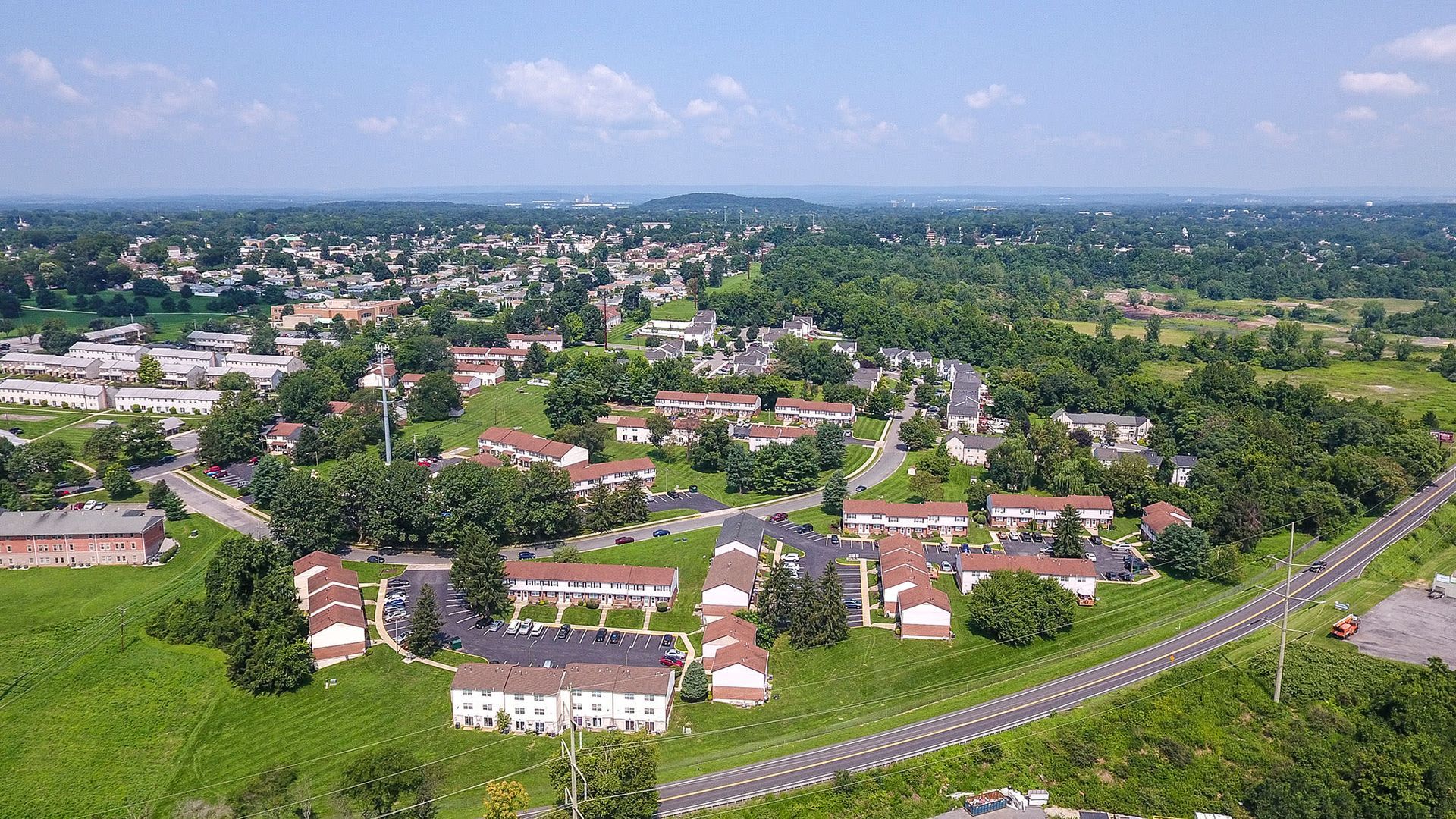 Aerial view of a suburban apartment community with multiple buildings and green spaces. Contact us today to learn more about our pet-friendly 1, 2, 3, and 4-bedroom apartments for rent in Bethlehem, PA. At River Pointe Townhomes, you’ll enjoy a prime location near Lehigh River and all the amenities and extras that make your life comfortable. We can’t wait to welcome you home!