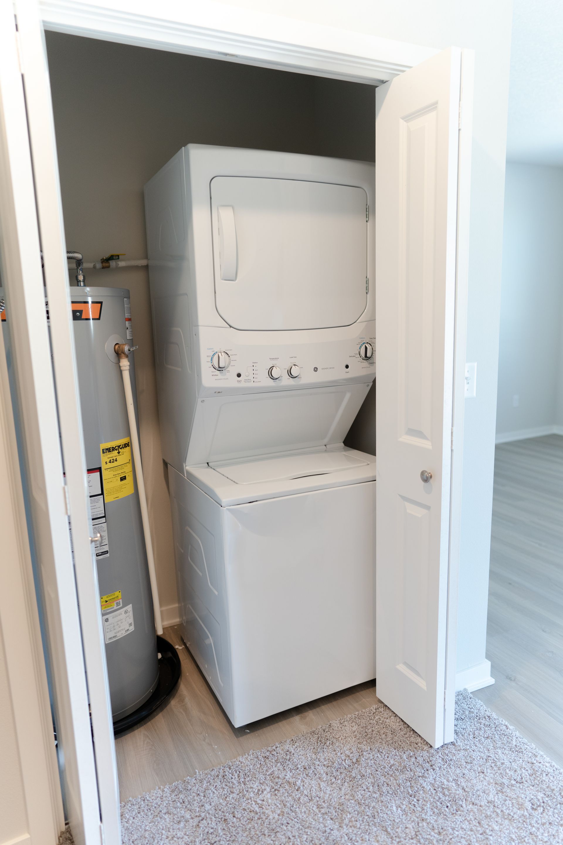 A washer and dryer are stacked on top of each other in a closet.