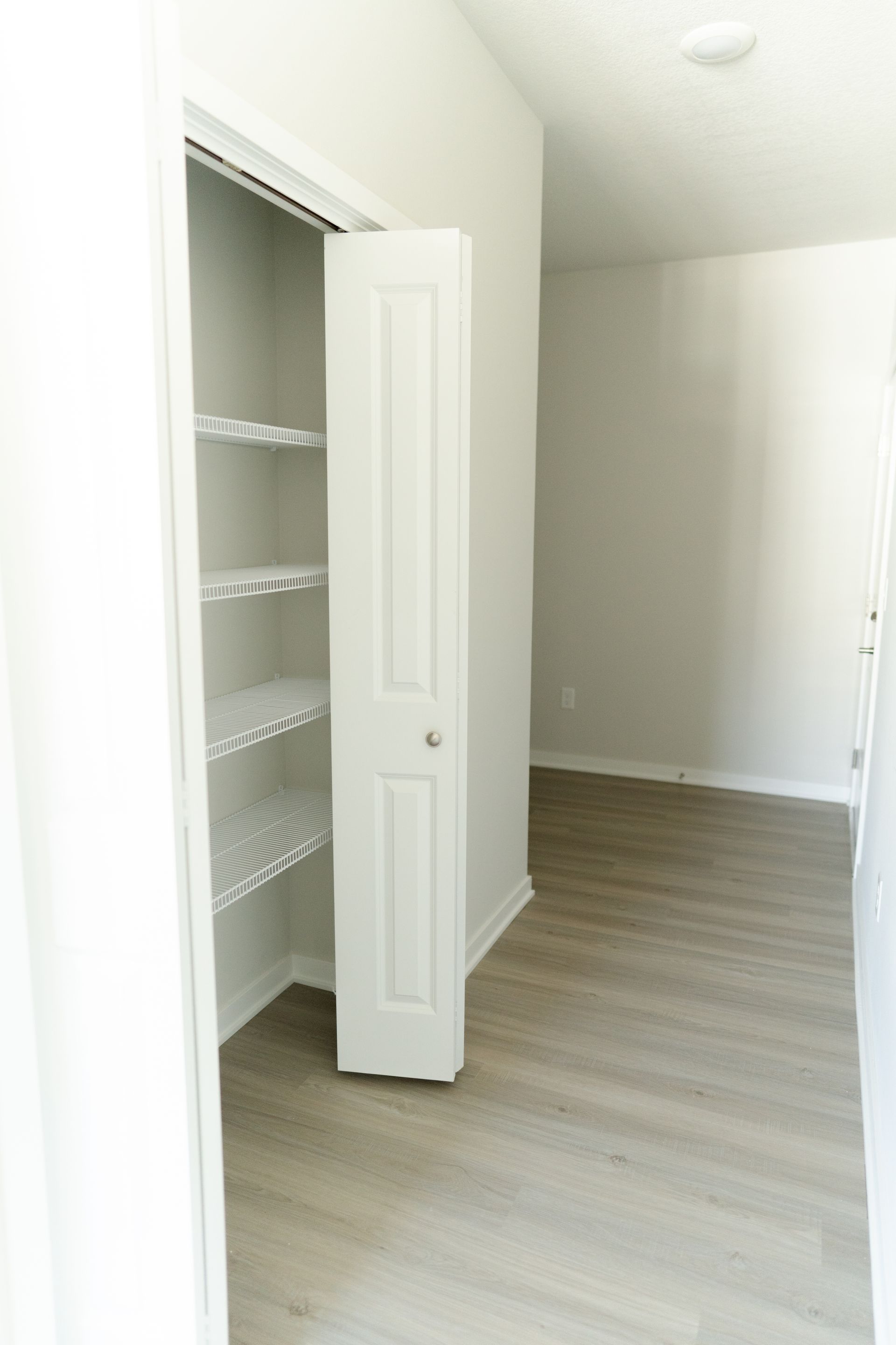 An empty room with a closet and shelves in it.