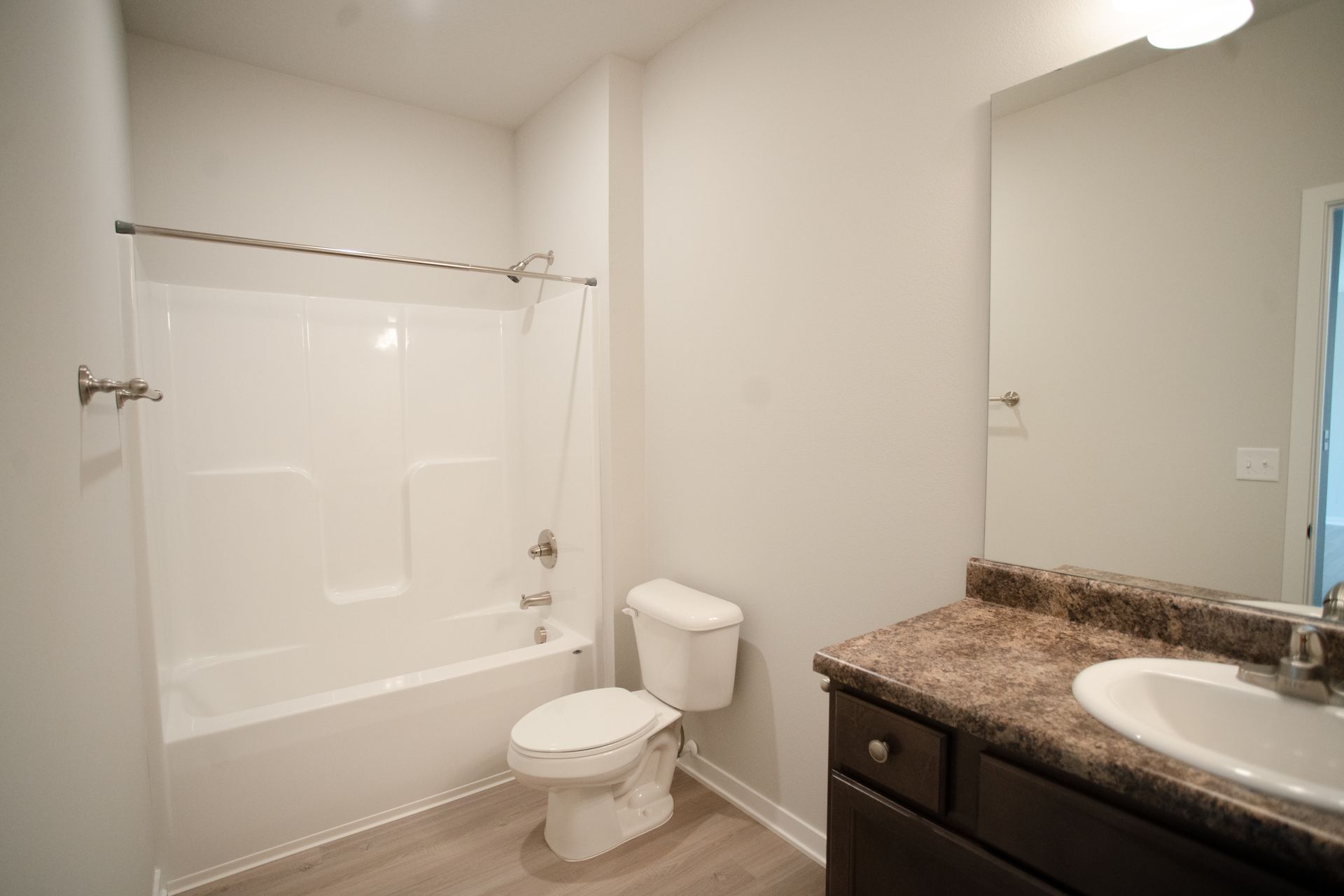 A bathroom with a toilet , sink and bathtub.