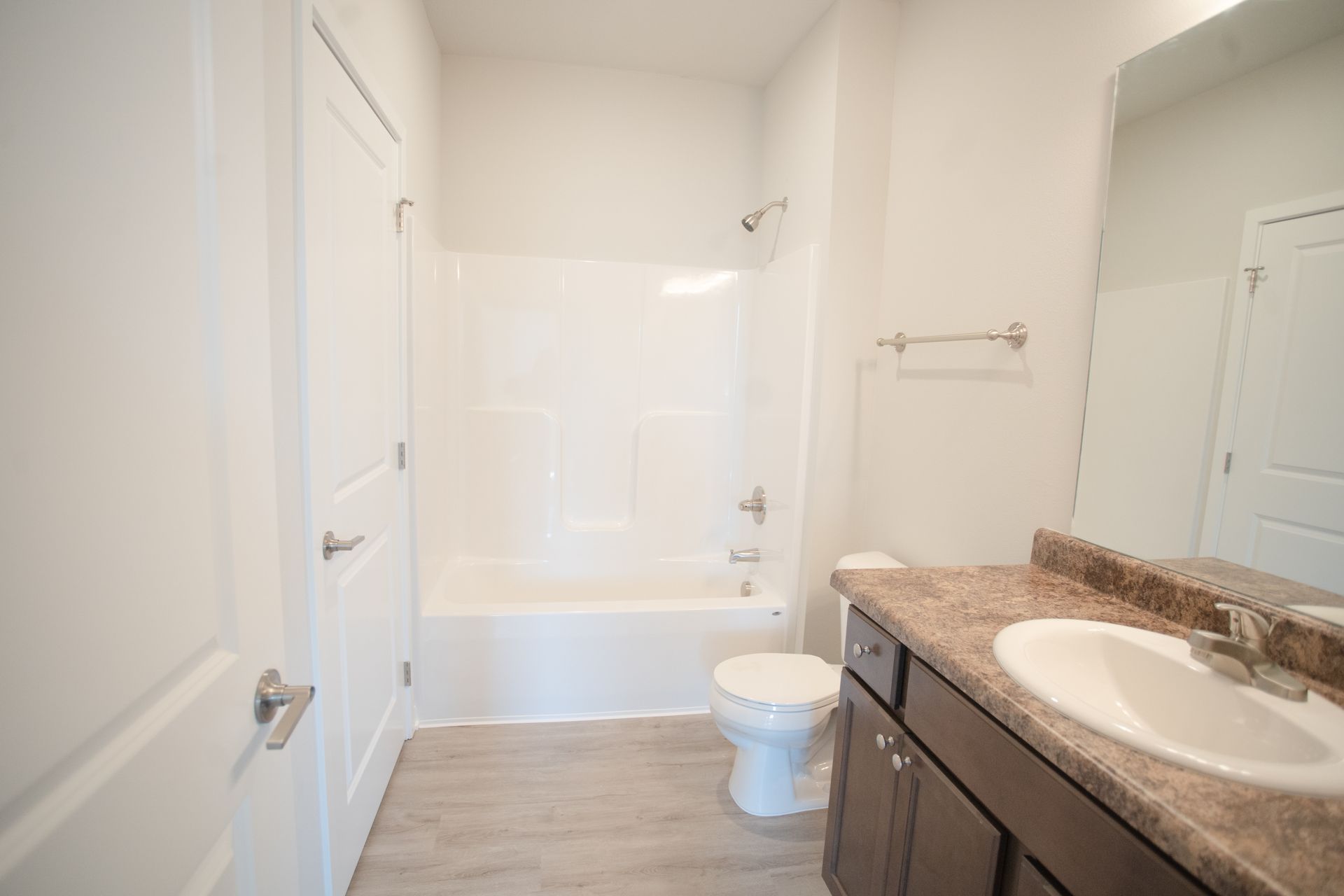 A bathroom with a sink , toilet , bathtub and mirror.