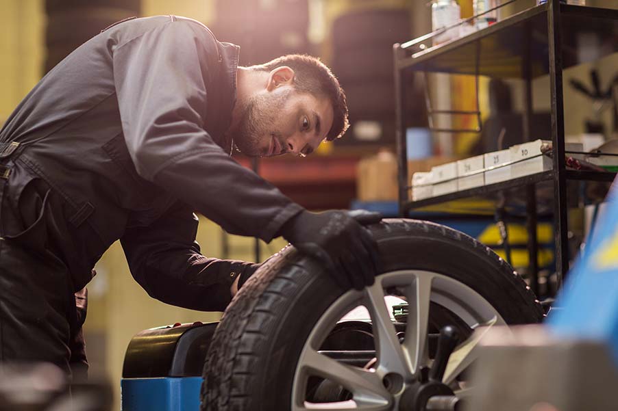 A man is working on a tire in a garage.
