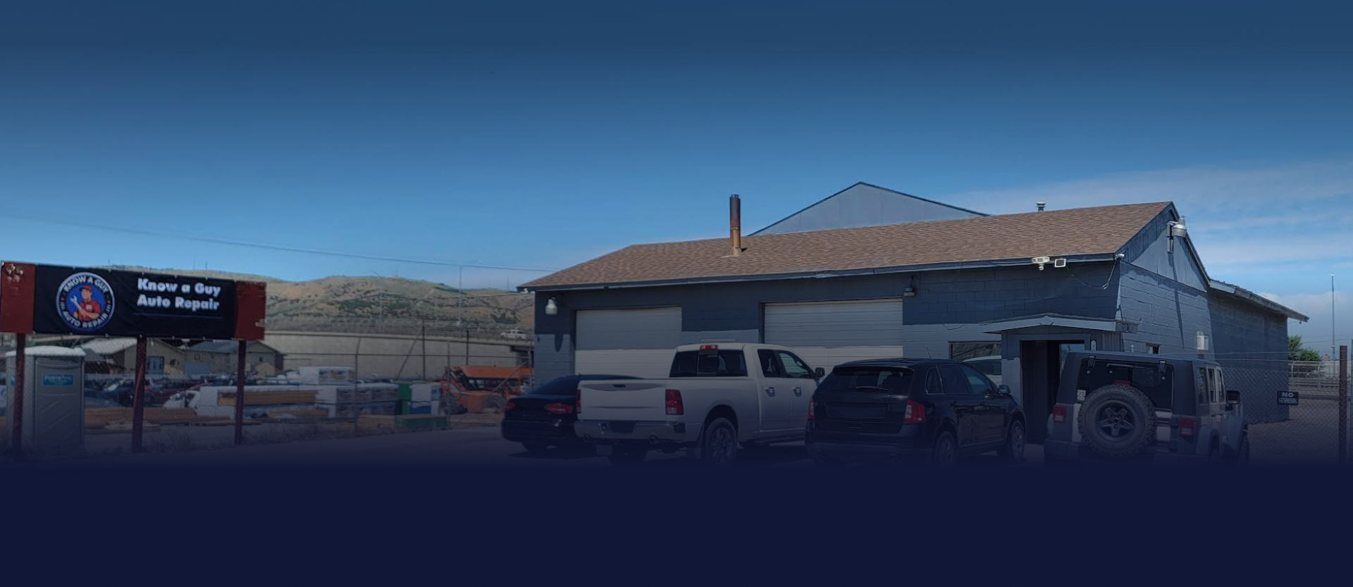 A rural building with vehicles parked outside under a clear blue sky. A sign on the left likely identifies the location | Know A Guy Auto Repair