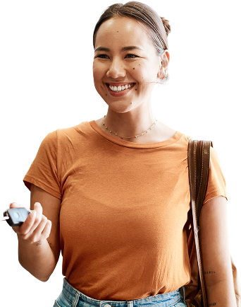 Woman smiling, holding a car key, wearing an orange shirt, and carrying a backpack | Know A Guy Auto Repair