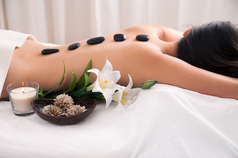 Person Receiving a Hot Stone Massage on a Spa Table — A1 Coffs Harbour in Coffs Harbour, NSW