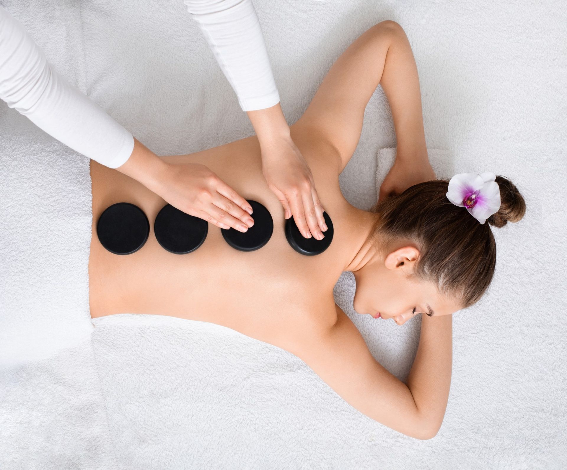 Person Receiving a Stone Massage on Their Back in a Spa Setting — A1 Coffs Harbour in Coffs Harbour, NSW