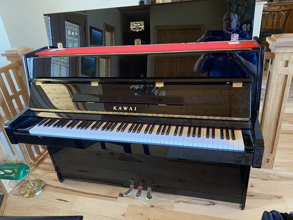 Kitchen with a wooden island, antique-style cabinet, wine rack, and green wall; hardwood floors.