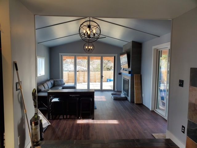 A living room with a blue couch , a dining table , and a skylight.