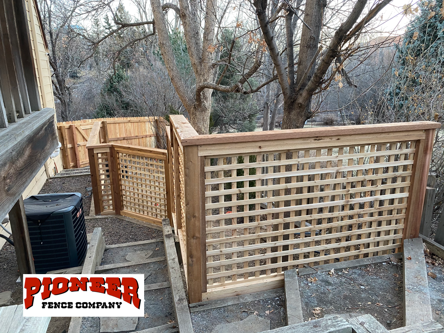 A person is standing in front of a house with a dog.