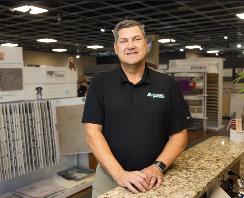 A man in a black shirt is standing at a counter in a store