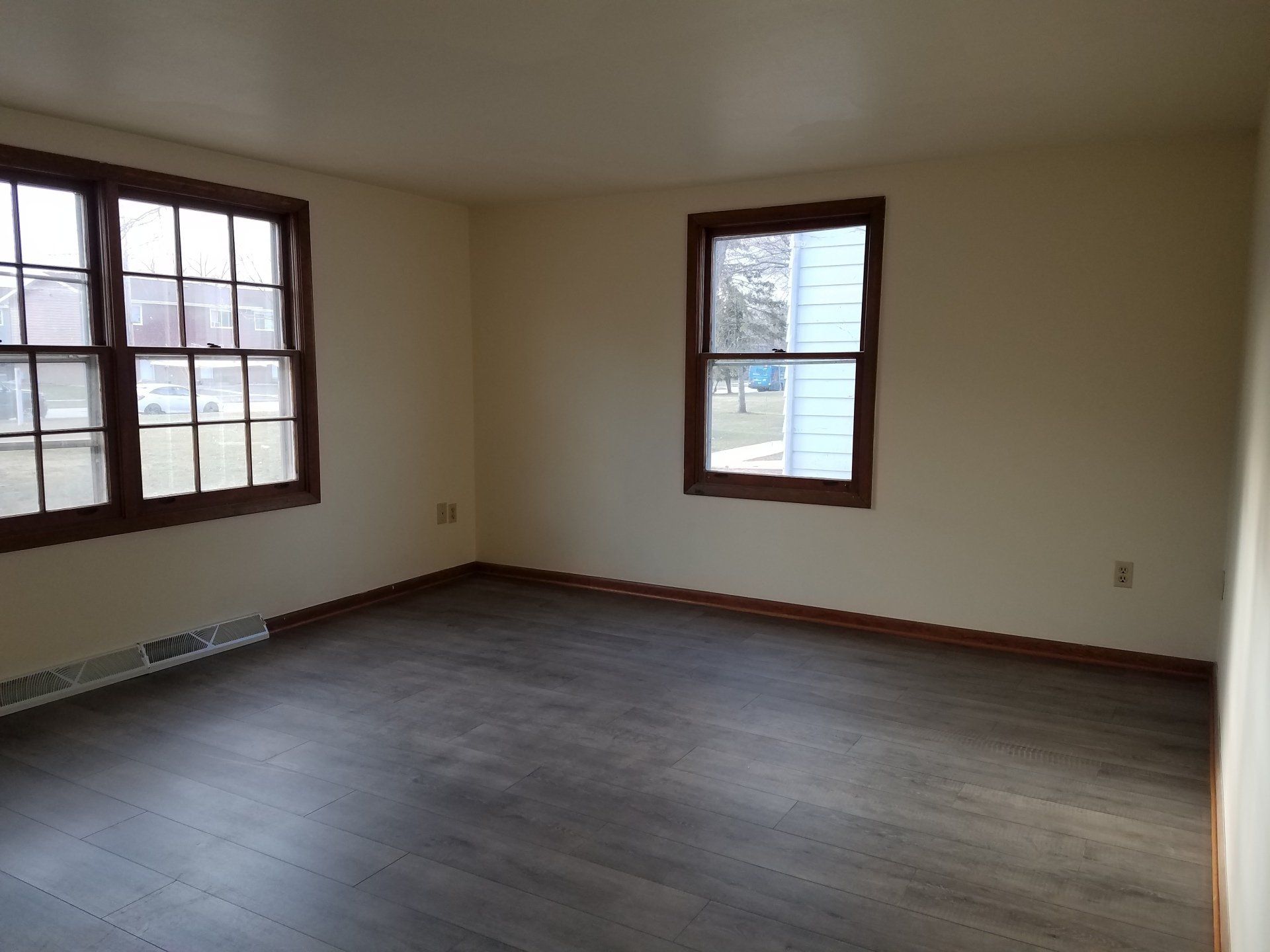 Bedroom with grey floor and windows.