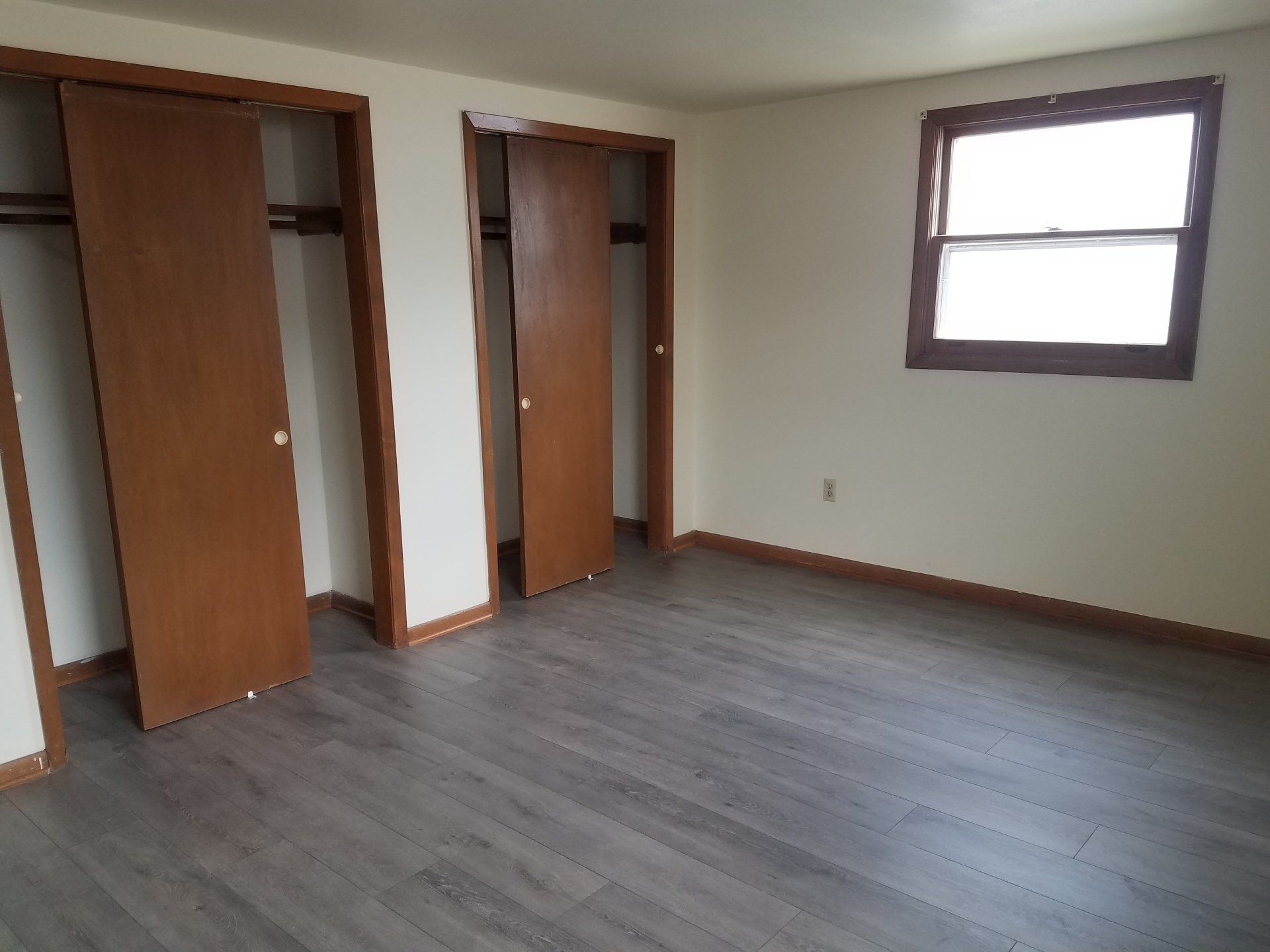 Bedroom with grey floor and closet.