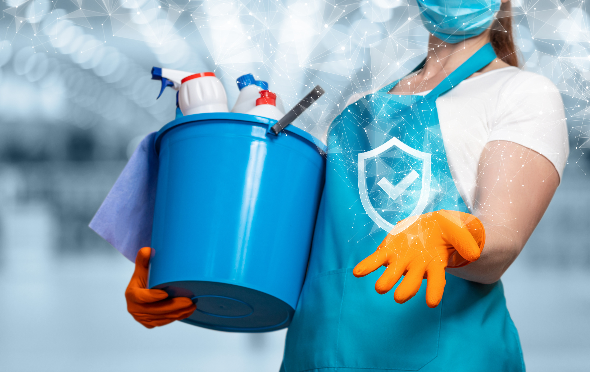 Person in apron and mask holding cleaning supplies: bucket, sprays, cloth. Orange gloves. Blue and white colors.
