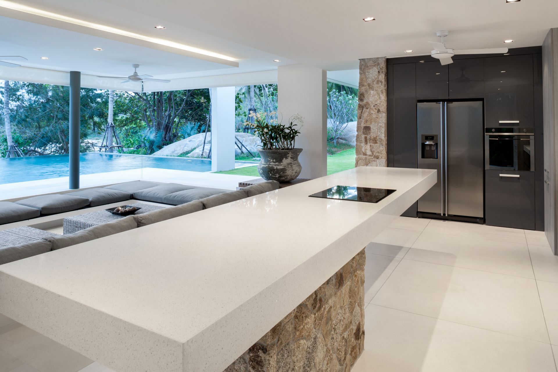 Sleek modern kitchen design with a long center island fitted with a white quartz countertop.