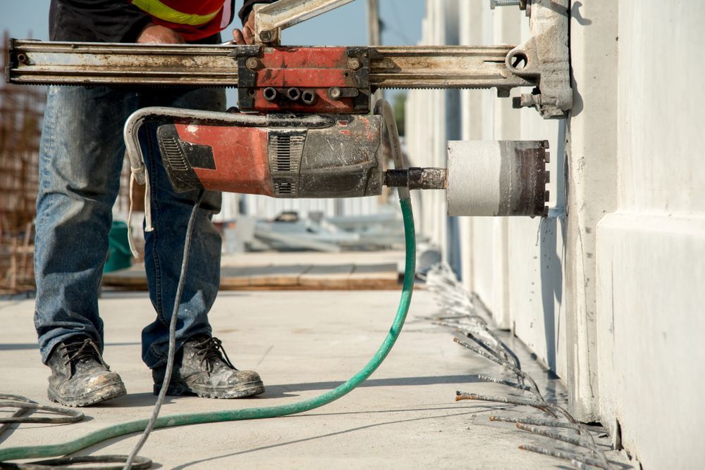 Construction Worker Using a Core Drill on A Concrete Wall — Ultra Services Ground Pavement & Building in Mudgee, NSW