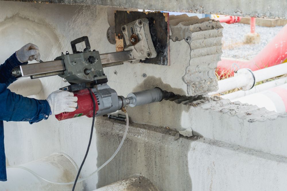 Worker Using a Core Drill to Bore a Hole Into Concrete — Ultra Services Ground Pavement & Building in Cobar, NSW