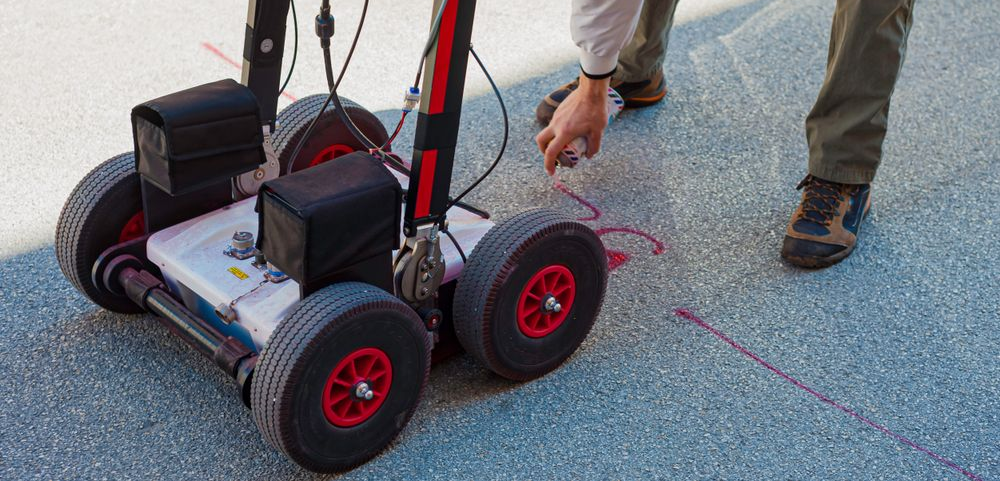 Person using ground-penetrating radar on a blue surface — Ultra Services Ground Pavement & Building in Abercrombie, NSW