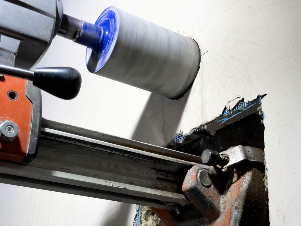 A Core Drill in Action, Creating a Large Hole in A White Wall — Ultra Services Ground Pavement & Building in Bourke, NSW