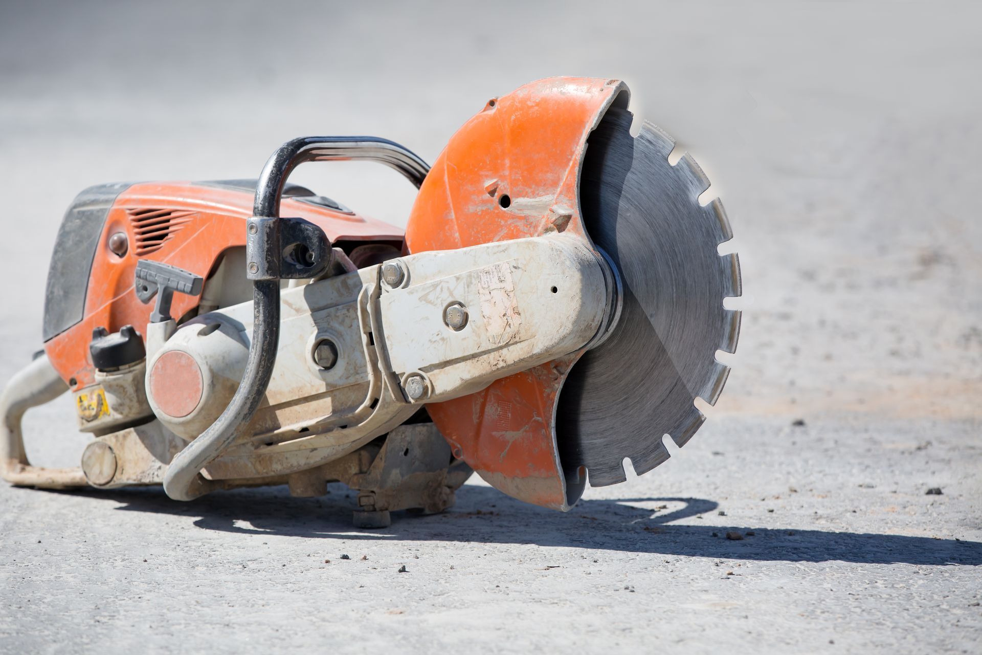 Orange and White Concrete Saw Resting on A Concrete Surface — Ultra Services Ground Pavement & Building in Cobar, NSW