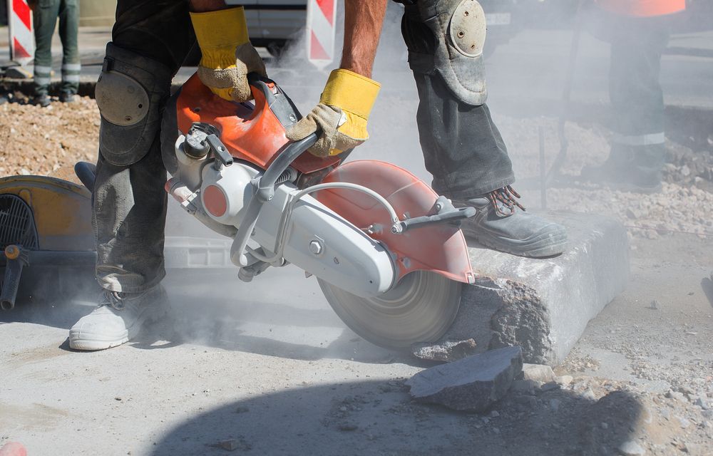 Worker Using a Concrete Saw on Asphalt, Creating Dust — Ultra Services Ground Pavement & Building in Abercrombie, NSW