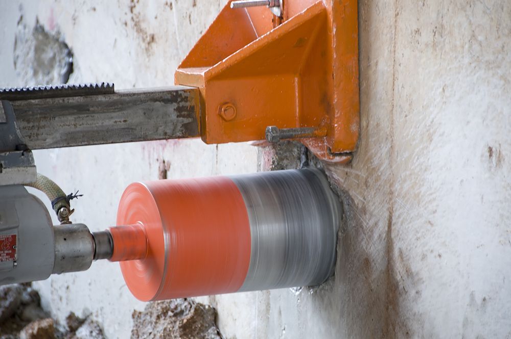 Orange Core Drill Boring a Hole in A Concrete Wall; Water Spraying — Ultra Services Ground Pavement & Building in Orange, NSW